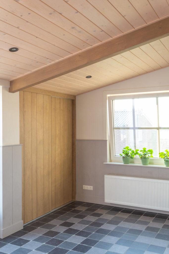 Renovatie boerderij speelkamer met houten schuifdeur.